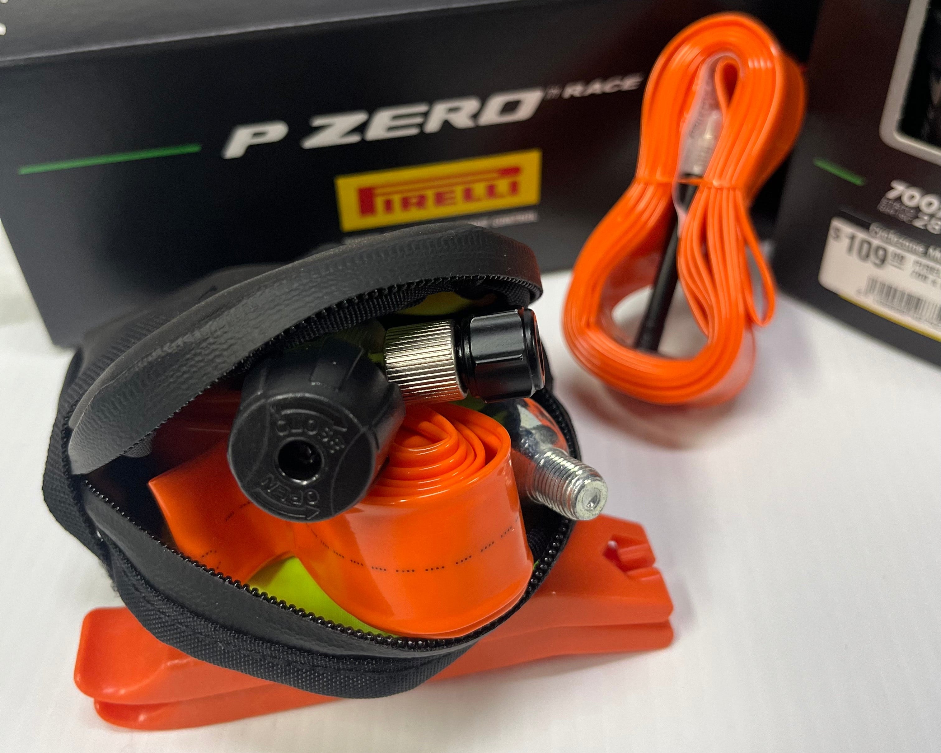 Pirelli P Zero Race tire pressure monitor with orange cable and tool on a white background